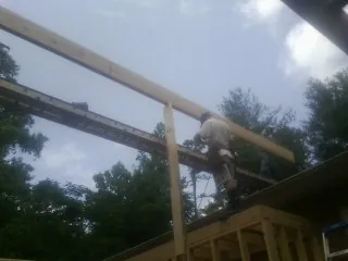 Carpenter setting a ridge beam over a new addition frame — Ice Dam Removal by Roofing Brothers in Copenhagen