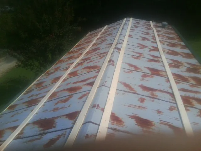 Rusted metal roof panels with new wood purlins before replacement — Storm Damage Roof Repair in Copenhagen by Roofing Brothers