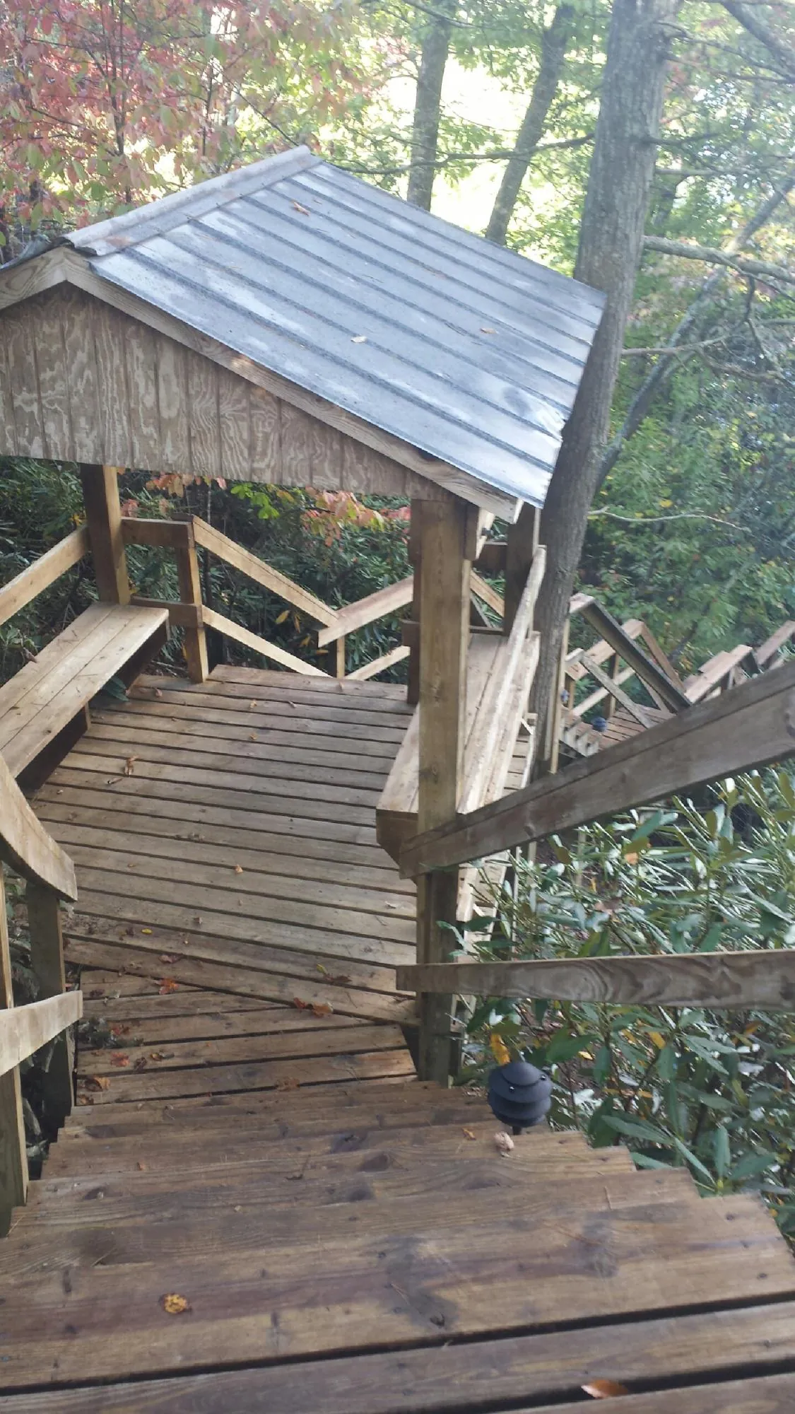 Metal roofed shelter over wooden steps on a wooded walkway — Skylight Repair & Installation work by our crew in Copenhagen